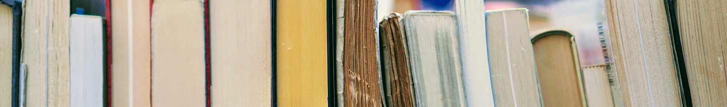 A row of old books on a library shelf