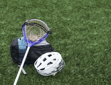 a lacrosse stick, helmet, and backpacks