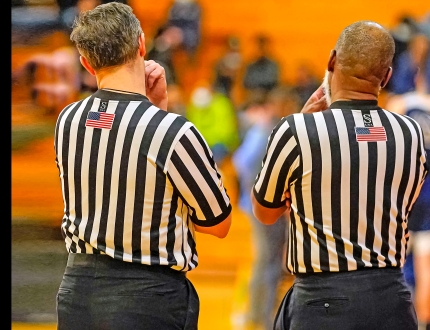 photo of the back of two referees at a game