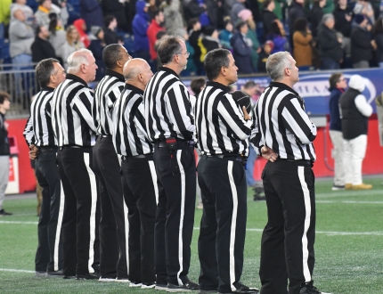 a group of officials out standing in their field