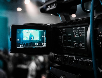 a professional video camera recording something in the distance