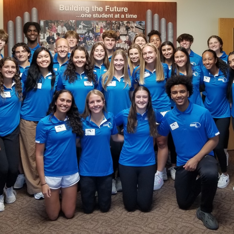 A group of student athletes in blue shirts